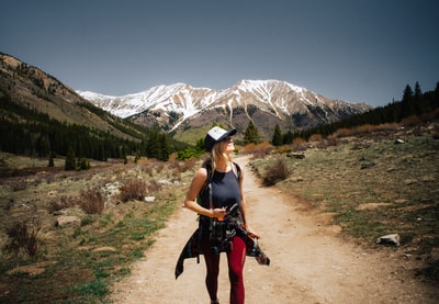 布朗走在路上的女人举着相机
